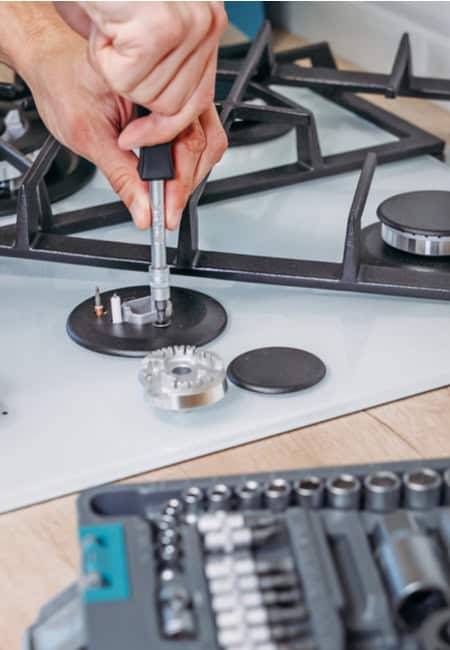 an EZFix plumber fixing a stove with a screw