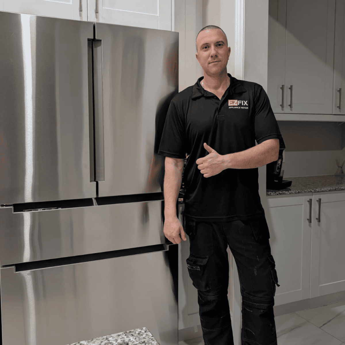 EZFIX appliance repair technician standing next to a serviced refrigerator in a residential kitchen